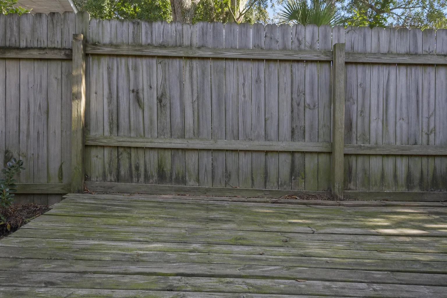 Before deck and fence cleaning in Jacksonville with gray weathered wood and algae