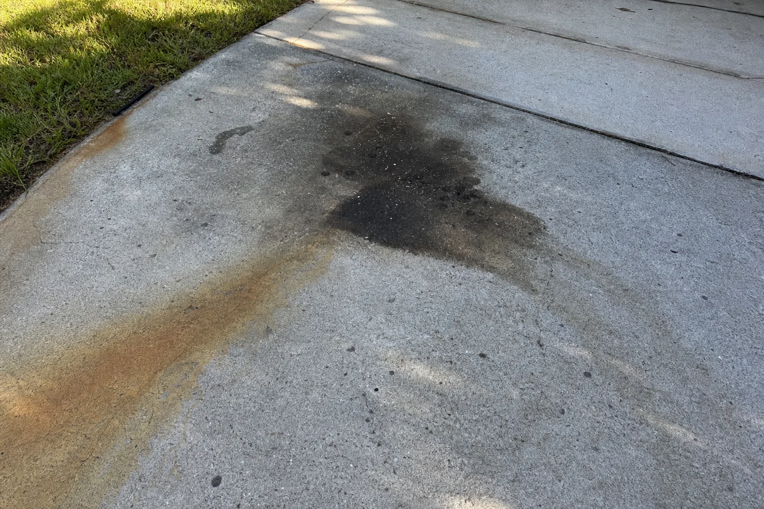 Before oil stain treatment on Jacksonville concrete driveway